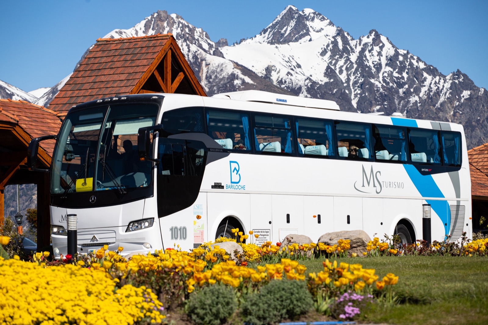 Ómnibus de la flota propia de MS Turismo frente a las montañas